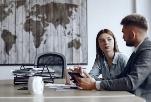 man-uses-tablet-business-partners-business-meeting-people-are-sitting-table_1157-40417